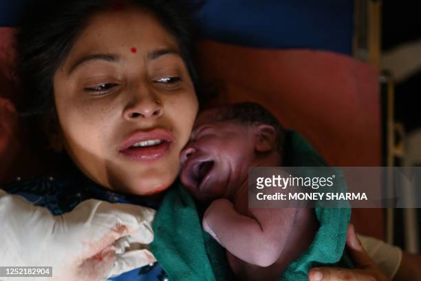 This photograph taken on April 24, 2023 shows a newly born daughter of Manu Bala after her delivery at a civil hospital in Dehra, in Kangra district...
