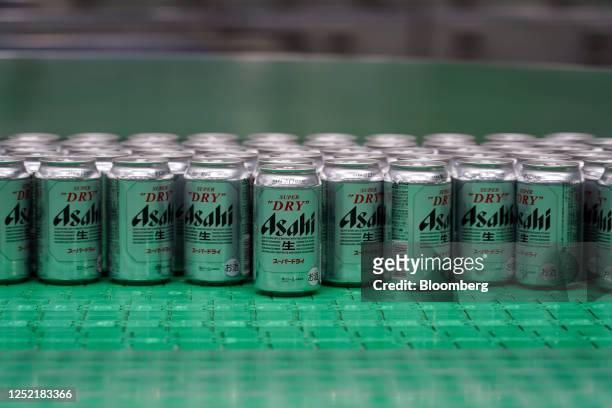 Cans of Asahi Super Dry beer move on the production line inside the Asahi Breweries Ibaraki plant, operated by Asahi Breweries Ltd., a unit of Asahi...