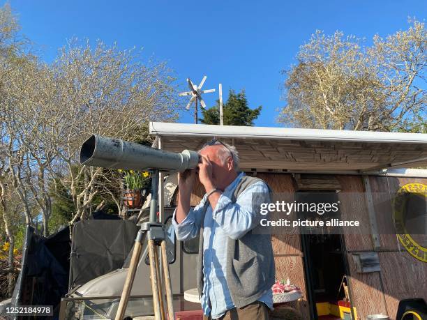 April 2023, Great Britain, Dores: "Nessie hunter" Steve Feltham looks through a telescope at Loch Ness. For decades, Steve Feltham has been observing...