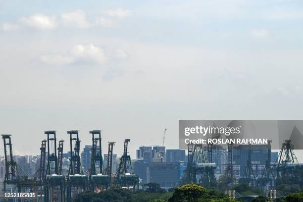 View shows cranes at Tanjong Pagar port terminal with skyscrapers in the background in Singapore on April 26, 2023.