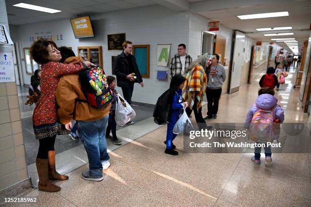 Lisa Mohorney, the dean of students, gets greeted with a hug from a 5th grader at the start of school in Nelsonville, Ohio on March 20, 2023. The...