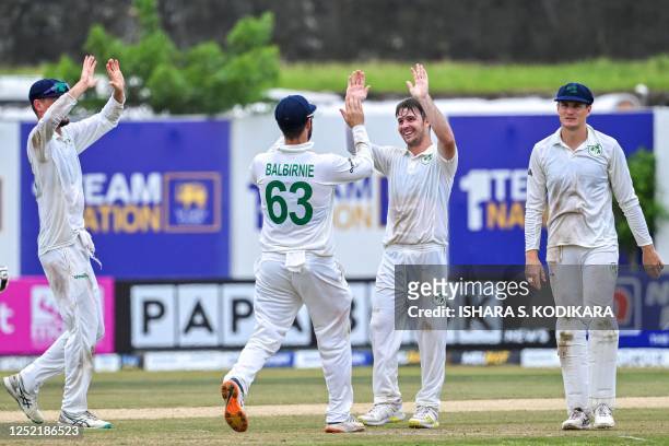 Ireland's Curtis Campher celebrates with teammates after the dismissal of Sri Lanka's Dimuth Karunaratne during third day of the second and final...