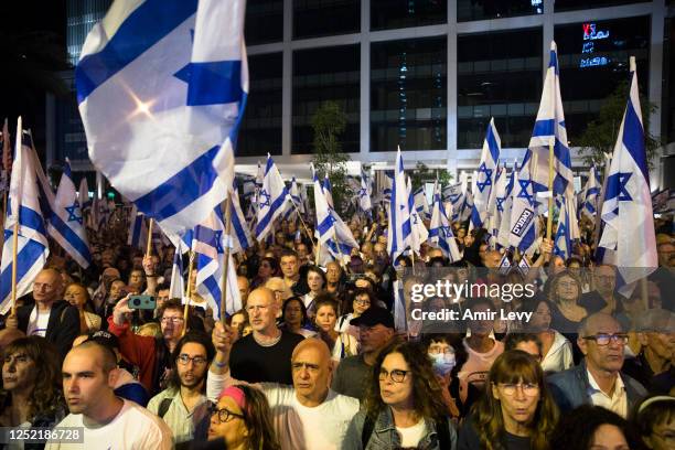 Protesters hold flags as they are protesting against the Israeli government's judicial overhaul during Israel's independence day on April 25, 2023 in...