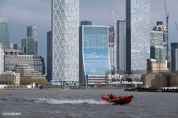 Thames Rocket rib speed boat passes One Canada Square and many other more recently built skyscrapers at the heart of Canary Wharf financial district...