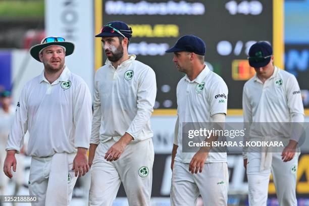 Ireland's captain Andrew Balbirnie walks back to the pavilion with Andrew McBrine and Paul Stirling as rain stops play during third day of the second...