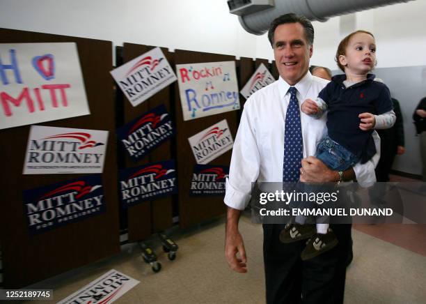 Republican presidential candidate Mitt Romney carries his grandson Parker while arriving at a campaign rally in Nashua, 06 January 2008. New...