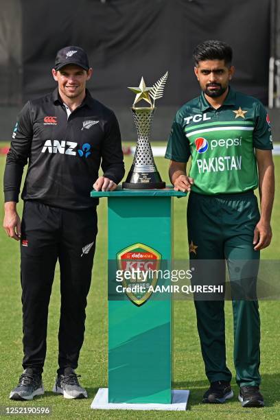 Pakistan's captain Babar Azam and his New Zealand's counterpart Tom Latham pose with the trophy at the Rawalpindi Cricket Stadium in Rawalpindi on...