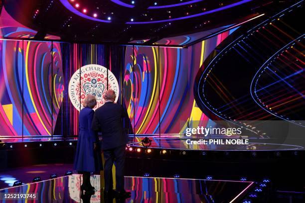 Britain's King Charles III and Britain's Camilla, Queen Consort stand on stage after switching on the stage lighting as they visit the host venue of...