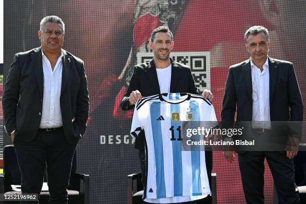 Former player Maximiliano Rodriguez holds a jersey of Argentina accompanied by AFA President Claudio Tapia and Ignacio Astore President of Newell's...