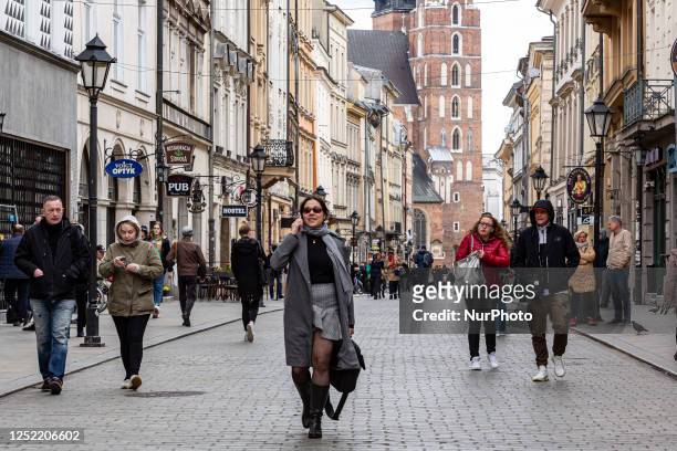 Visitors walk on Florianska street in the Old Town of Krakow, Poland on April 26, 2023. Despite inflation and a crisis connected with the war in...