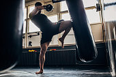 Man kick boxer training alone in gym