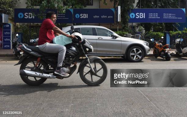 Bicycle rider passes by a State Bank Of India branch in Mumbai, India, 26 April, 2023. The State Bank of India, the country's largest lender, plans...