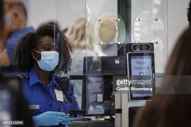 Transportation Security Administration agent operates a Credential Authentication Technology identity verification machine to screen departing...