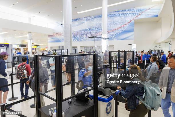 Traveler, bottom right, uses a Credential Authentication Technology identity verification machine at a Transportation Security Administration...