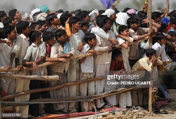 Supporters of Bahujan Samaj Party President and Chief Minister of Uttar Pradesh state, Mayawati Kumari wait and watch as she leaves a political rally...