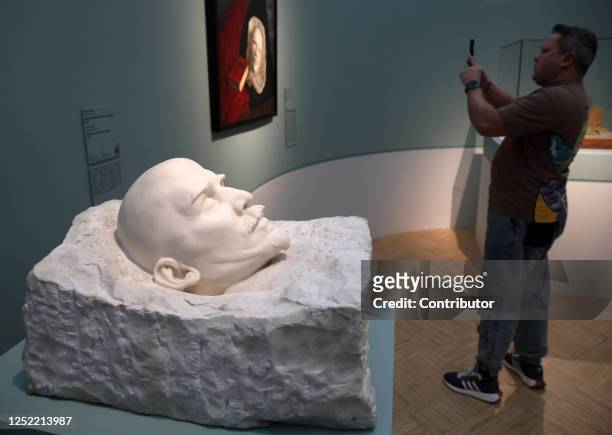 Man takes a smartphone photo of the death masks of former Soviet Union founder and leader Vladimir Lenin while visiting the "In Memoriam: Stopped...