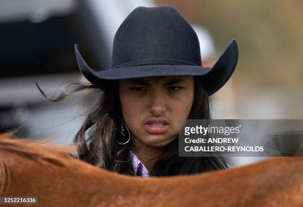 Morissa Hall prepares her horse before a barrel race during a local competition, part of the National Barrel Horse Association, at Triple Creek Farm...
