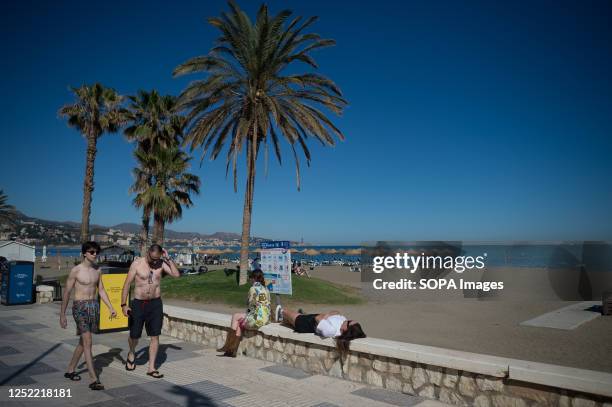 Woman is seen resting on the promenade at 'La Malagueta' beach as she enjoys the good weather amid an unusual heat wave. Spain is experiencing an...