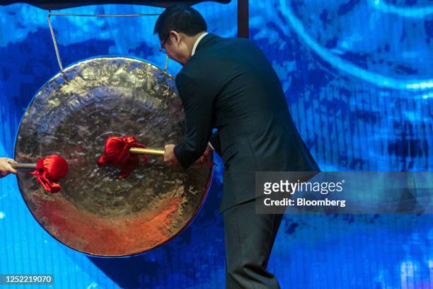 Wu Xiangdong, chairman and founder of ZJLD Group Inc., strikes a gong during the company's listening ceremony at the Hong Kong Stock Exchange in Hong...