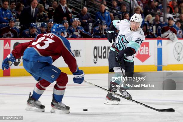 Vince Dunn of the Seattle Kraken shoots while Matt Nieto of the Colorado Avalanche defends in Game Five of the First Round of the 2023 Stanley Cup...