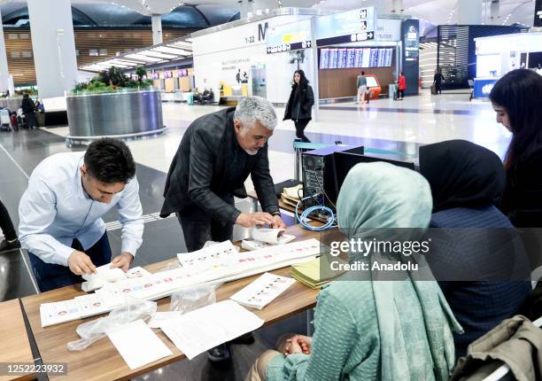 Election workers check ballots as Turks living abroad cast their votes in presidential and parliamentary elections at Istanbul Airport on April 27,...