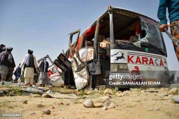 Taliban security personnel inspect a mangled private bus after it met with an accident on the Kandahar-Kabul highway in Daman district of Kandahar...