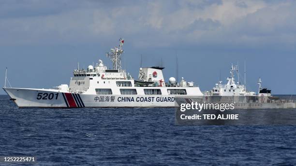 This photo taken on April 23, 2023 shows the Philippine coast guard vessel BRP Malapascua manoeuvering as a Chinese coast guard ship cuts its path at...