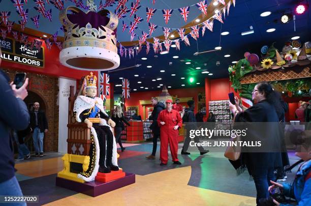 Shoppers take pictures of a full size LEGO figure depicting Britain's King Charles III at Hamleys toy store in central London on April 27, 2023. The...