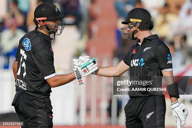 New Zealand's Will Young celebrates with his teammate Daryl Mitchell after scoring a half-century during the first one-day international cricket...