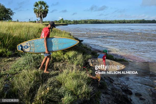 People prepare to surf the waves of a tidal bore known as "Pororoca" at Mearim River in Arari, Maranhao state, Brazil, on April 22, 2023. - Pororoca,...