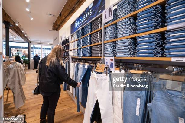 Customer browses the jeans for sale on the opening day of the new Uniqlo store, operated by Fast Retailing Co., in the Covent Garden district of...