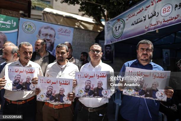 Palestinians hold photos of Hidir Adnan, a Palestinian prisoner who has been on hunger strike for 82 days in Israeli prisons, during the protest, in...