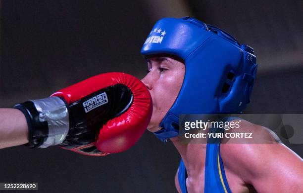Venezuela's Tayonis Cedeno receives a blow on her face from Russia's Ekaterina Paltseva during the women's 50kg boxing final at the 5th ALBA Games in...