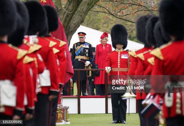 Britain's King Charles III and Britain's Camilla, Queen Consort stand before The King's Company of the Grenadier Guards during a ceremony to present...