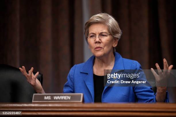 Sen. Elizabeth Warren speaks to a staff member before the start of a Senate Banking Committee hearing on oversight of credit reporting agencies, on...