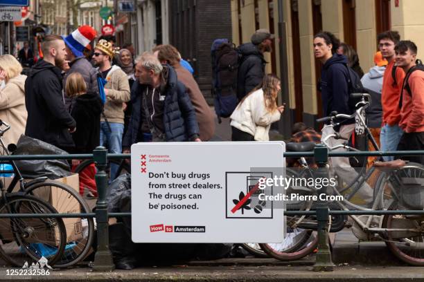 Board warns visitors of the Red Light District for drug dealers as people celebrate King's Day on April 27, 2023 in Amsterdam, Netherlands. April 27...
