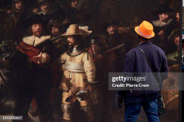 Man looks to a reproduction of the Night Watch by Rembrandt van Rijn as people celebrate King's Day on April 27, 2023 in Amsterdam, Netherlands....