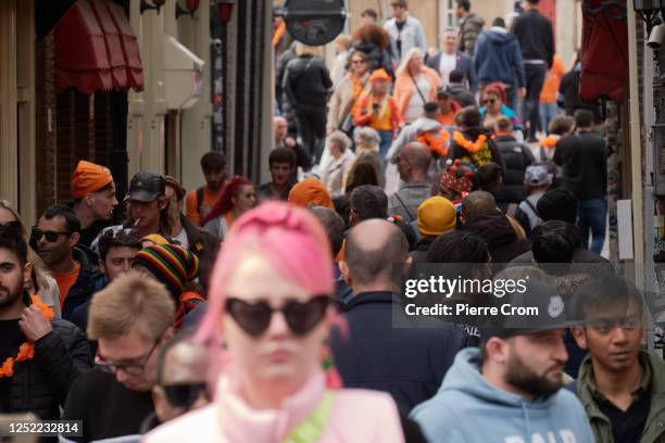 People walk through the Red Light District during King's Day on April 27, 2023 in Amsterdam, Netherlands. April 27 marks the birthday of King Willem...