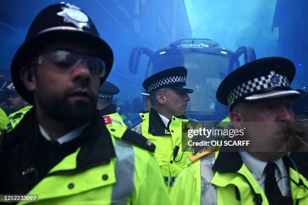 Police officers clear a past as Everton fans greet the arrival of their team bus ahead of the English Premier League football match between Everton...