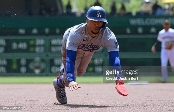 Mookie Betts of the Los Angeles Dodgers slides into third base after advancing on a single by Jason Heyward in the first inning during the game...