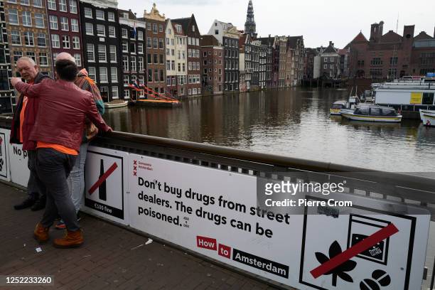 Board warns visitors for drug dealers near Central Station as people celebrate King's Day on April 27, 2023 in Amsterdam, Netherlands. April 27 marks...