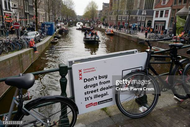 Board warns visitors of the Red Light District for drug dealers as people celebrate King's Day on April 27, 2023 in Amsterdam, Netherlands. April 27...