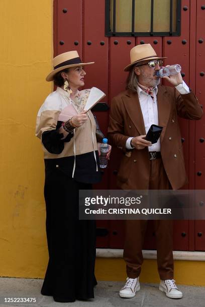 Visitors drink water as they arrive for the Feria de Abril bullfighting festival at La Maestranza bullring in Seville on April 27, 2023. - An...