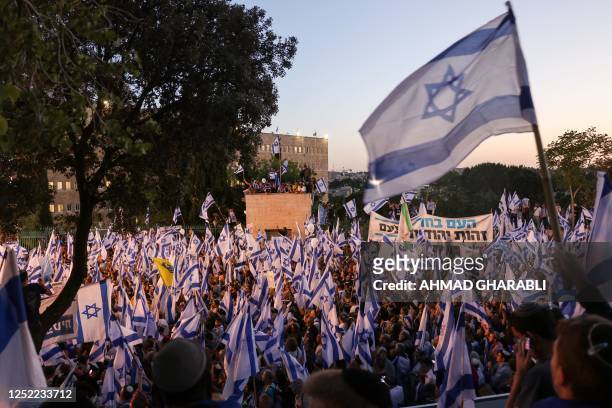 Pro-government protesters wave the Israeli flag as they gather near Israel's parliament in Jerusalem on April 27, 2023 in support of the hard-right...