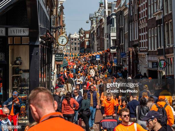 Thousands of people wearing orange clothes are seen walking along the streets of Amsterdam, during the celebration of King's Day, on April 27th, 2023.