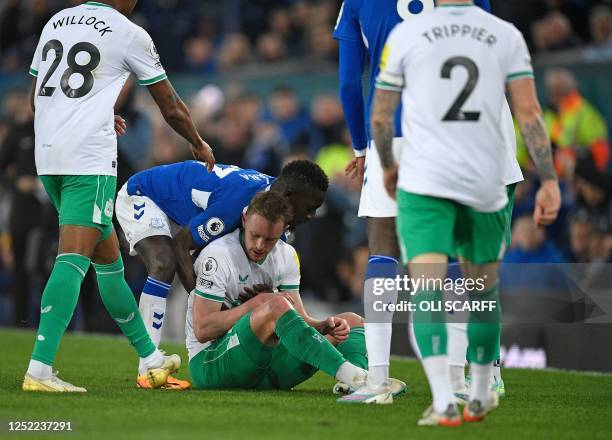 Everton players attempt to remove Newcastle United's English midfielder Sean Longstaff from the pitch, as they accuse him of timewasting after...