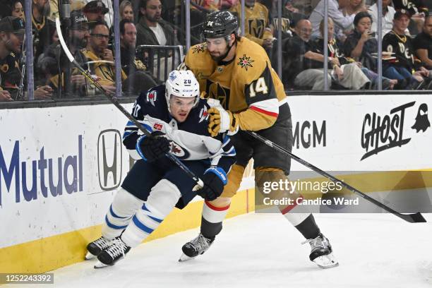 Karson Kuhlman of the Winnipeg Jets is checked by Nicolas Hague of the Vegas Golden Knights in the first period of Game Five of the First Round of...