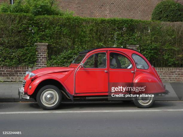 April 2023, North Rhine-Westphalia, Cologne: A red Citroen 2 CV - called duck - stands at the roadside Photo: Horst Galuschka/dpa