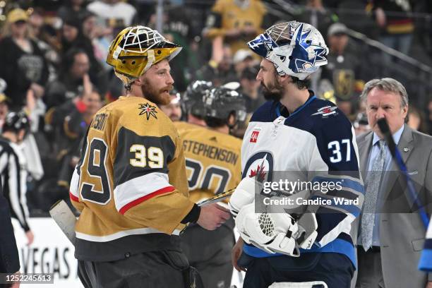 Laurent Brossoit of the Vegas Golden Knights and Connor Hellebuyck of the Winnipeg Jets shake hands at the end of Game Five of the First Round of the...