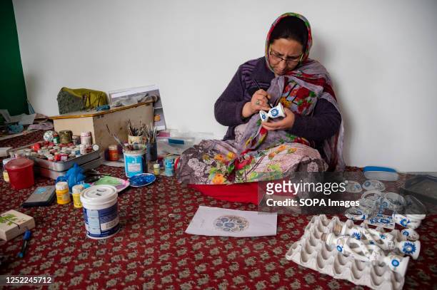 Woman artisan is seen designing a Paper Mache item at a workshop in Srinagar. Papier-Mache handicrafts, is an age-old craft that was introduced to...